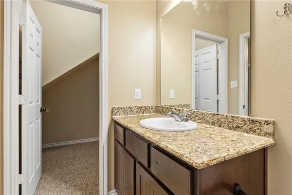 a bathroom with a granite countertop sink and a mirror