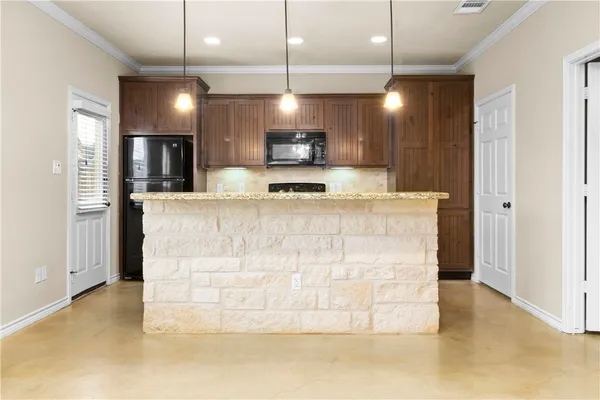 a large kitchen with a large counter top kitchen appliances and a ceiling fan