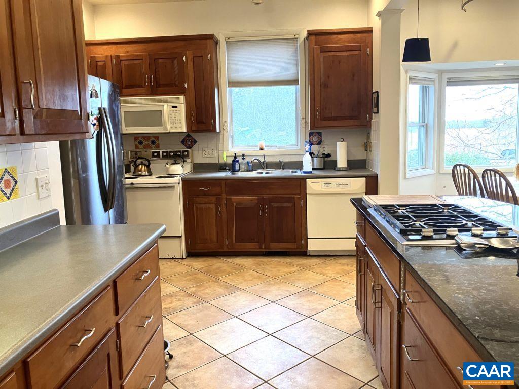 877 Holland Creek Road Louisa, VA 23093 - Photo 11 of 48 a kitchen with stainless steel appliances granite countertop a stove a sink and a microwave
