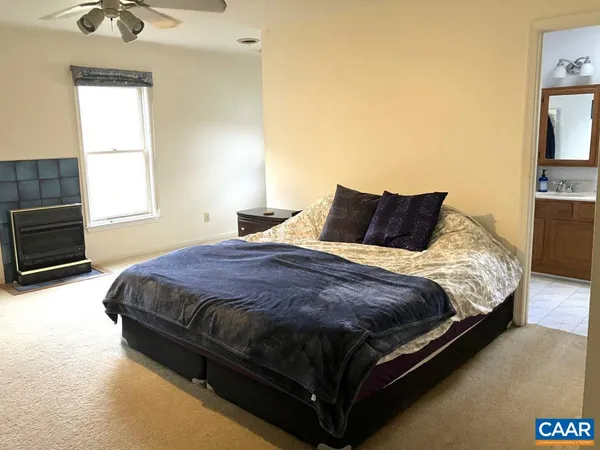 a spacious bedroom with a bed and a dresser