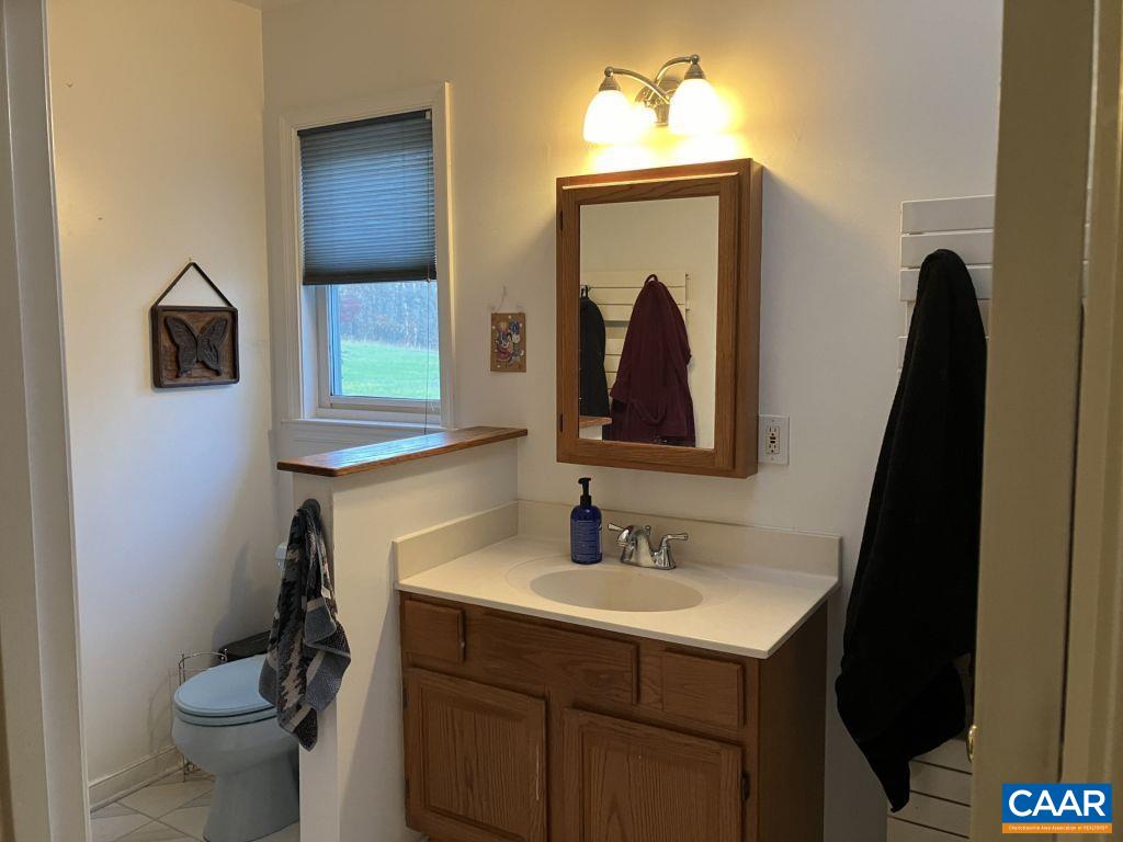 877 Holland Creek Road Louisa, VA 23093 - Photo 22 of 48 a bathroom with a toilet sink and mirror
