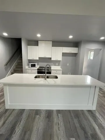 a living room with stainless steel appliances furniture a refrigerator and a stove top oven