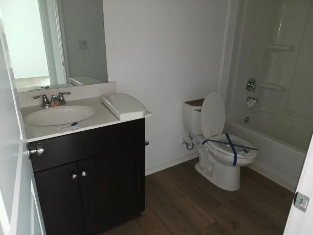 a view of a kitchen with a sink dishwasher cabinets and wooden floor