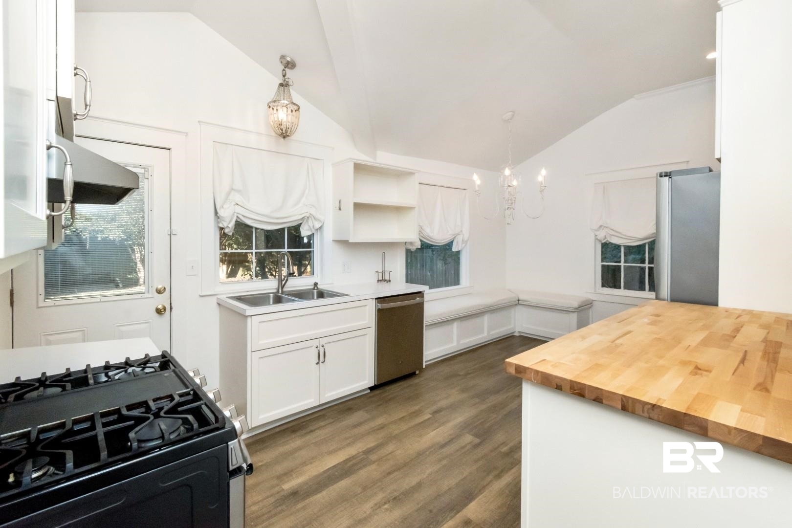 16 Princess Anne Road Mobile, AL 36608 - Photo 9 of 40 Kitchen with decorative light fixtures, white cabinets, appliances with stainless steel finishes, wood counters, and a chandelier