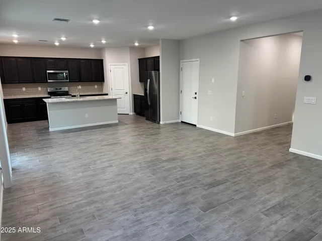 a view of kitchen with kitchen island a sink stainless steel appliances and cabinets