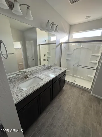 a bathroom with a granite countertop sink a toilet a mirror and shower