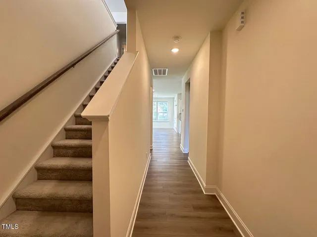 a view of staircase with wooden floor and white walls