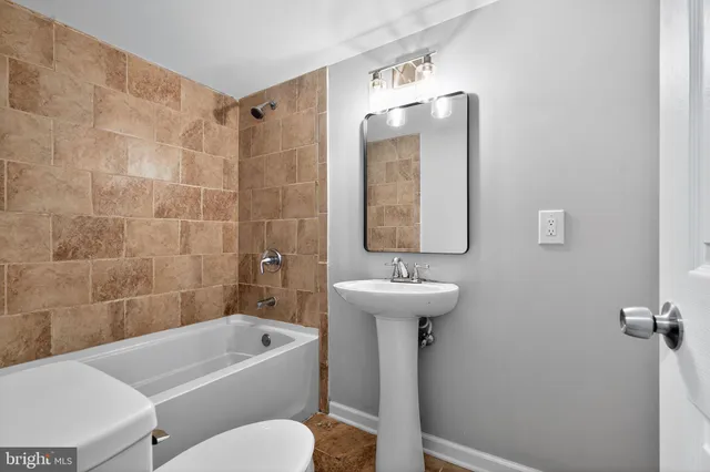 a bathroom with a sink a toilet and bathtub