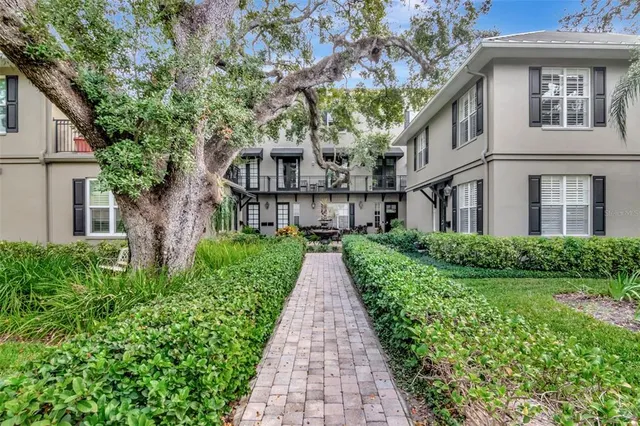 a view of a house with a yard and potted plants