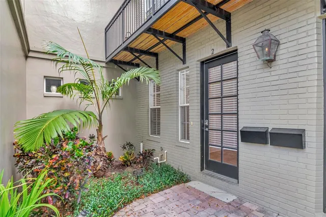 a view of a house with brick walls and flower plants