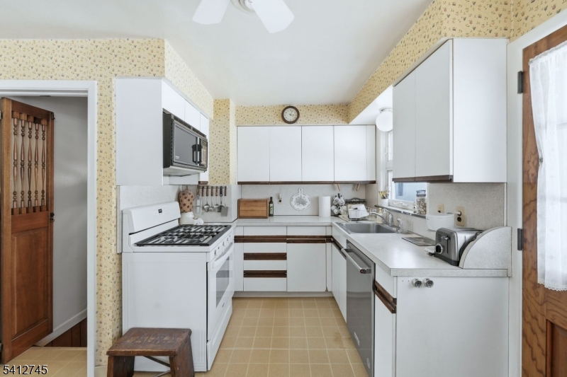 47 Clinton Avenue New Providence, NJ 07974 - Photo 14 of 43 a kitchen with stainless steel appliances a sink stove and cabinets