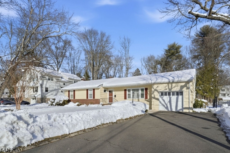 47 Clinton Avenue New Providence, NJ 07974 - Photo 34 of 43 a view of a white house with a yard covered in snow