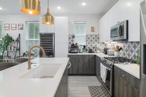 a kitchen with stainless steel appliances a sink stove and cabinets