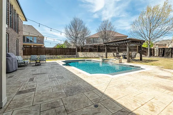 a view of a swimming pool with a lounge chair and palm trees