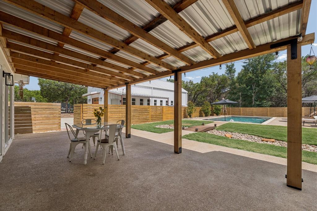 286 Benevolence Way China Spring, TX 76633 - Photo 29 of 37 Expansive outdoor living area featuring a covered patio with a wood-framed metal roof, concrete flooring, and an in-ground swimming pool