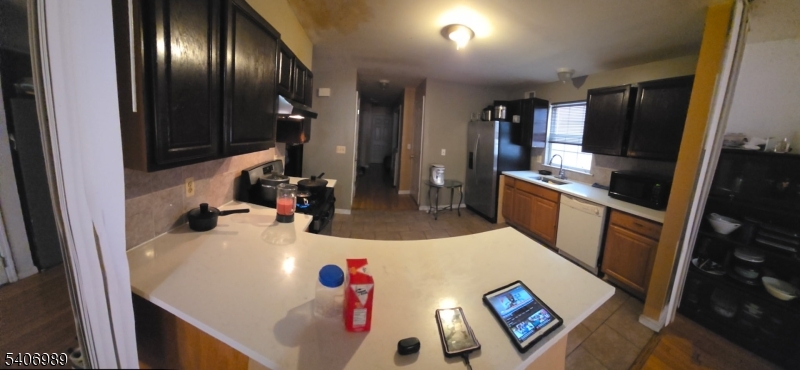 26 Clinton Place Newark, NJ 07108 - Photo 5 of 18 a kitchen with granite countertop stainless steel appliances a sink microwave and refrigerator
