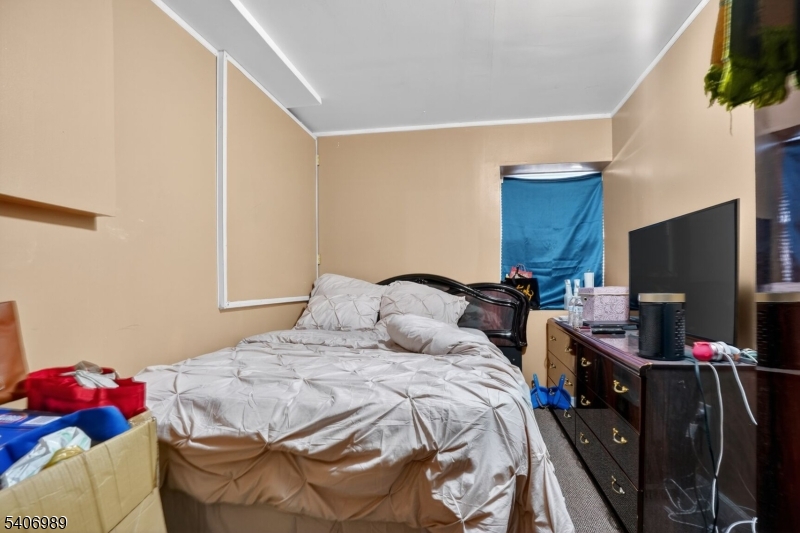 26 Clinton Place Newark, NJ 07108 - Photo 6 of 18 a bedroom with a bed and a flat tv screen on the dresser
