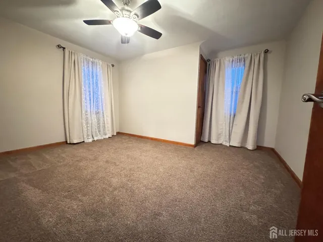 a view of a livingroom with a ceiling fan and window