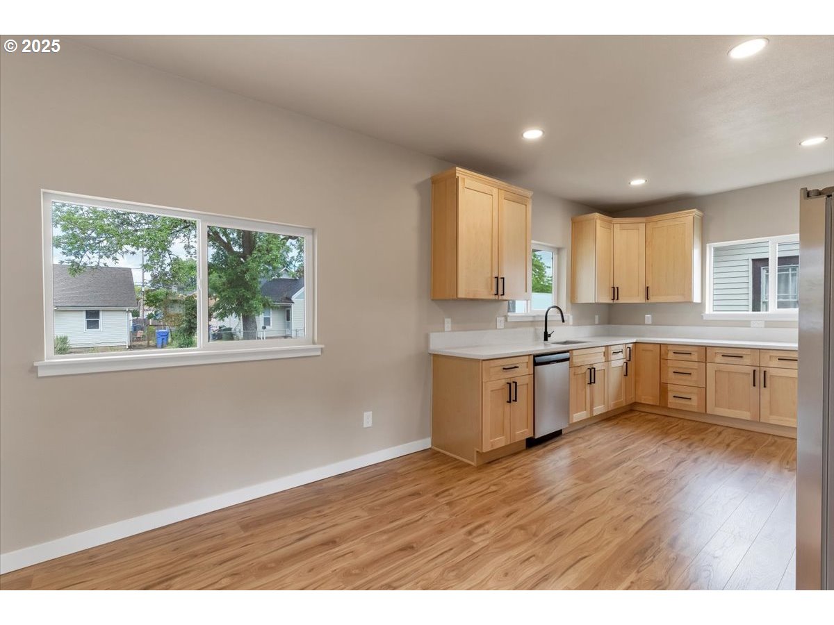 494 17th Street Northeast Salem, OR 97301 - Photo 12 of 44 a large kitchen with kitchen island white cabinets wooden floor and stainless steel appliances
