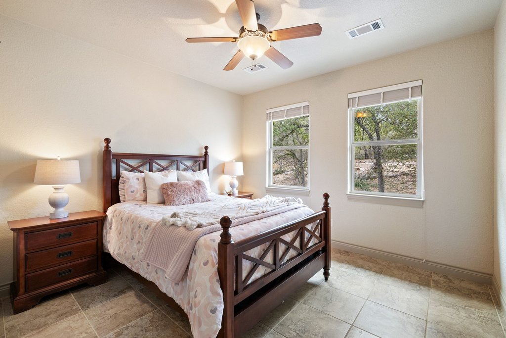 232 Crooked Oak Round Mountain, TX 78663 - Photo 20 of 40 a bedroom with a bed and a ceiling fan