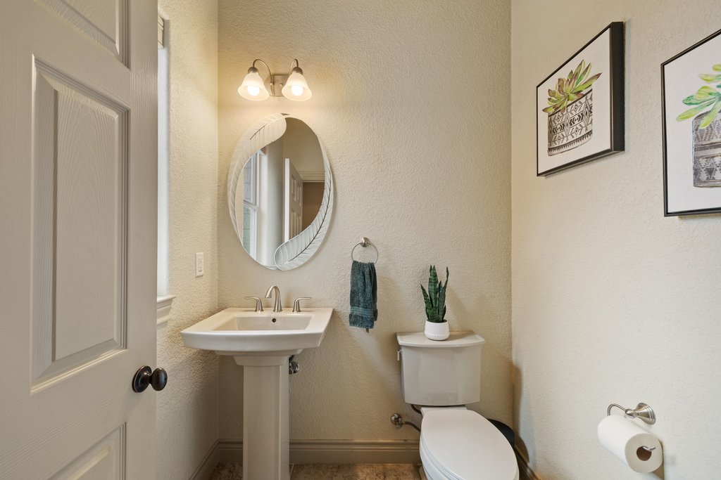 232 Crooked Oak Round Mountain, TX 78663 - Photo 24 of 40 a bathroom with a toilet sink and mirror