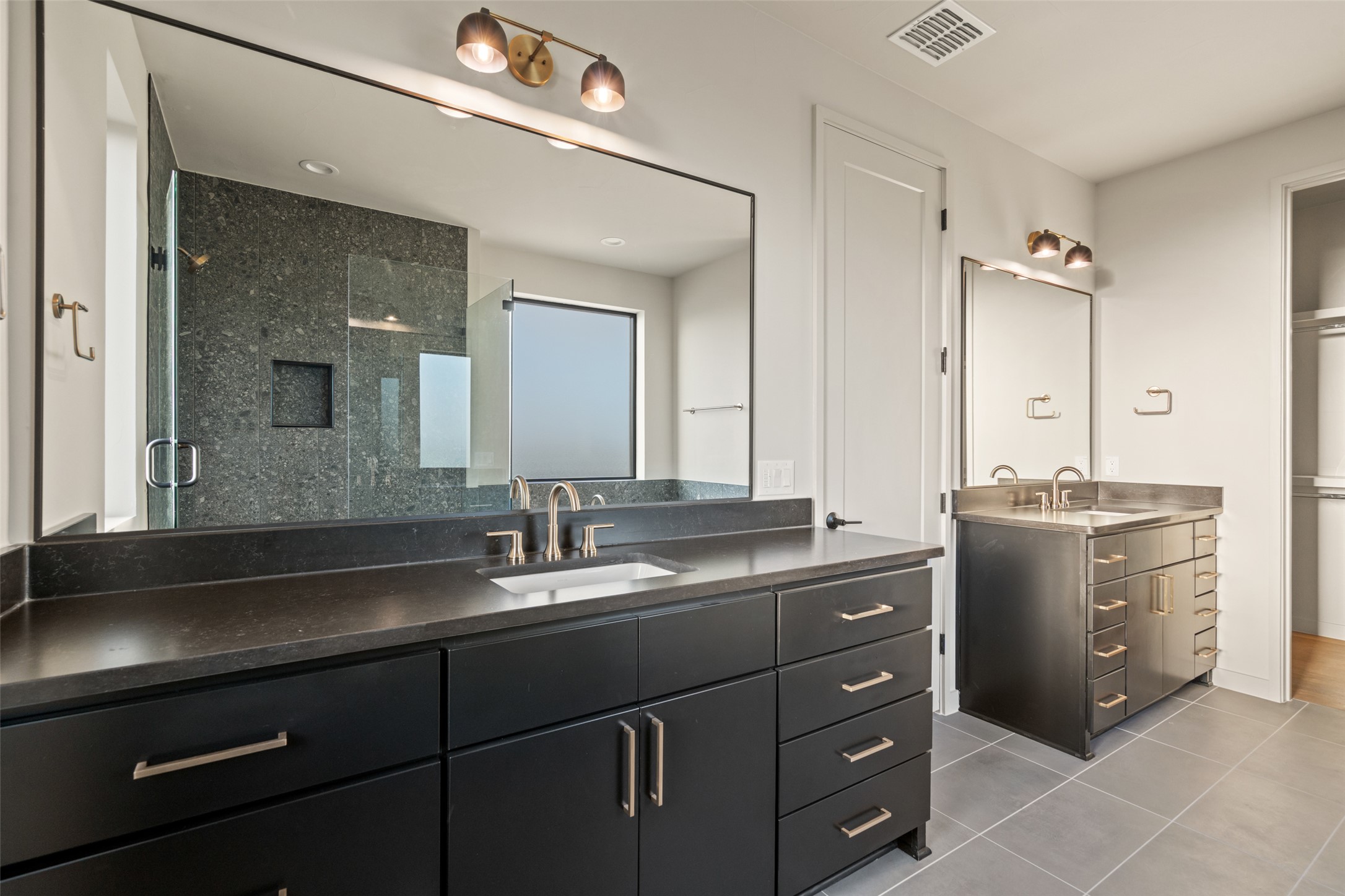 9803 Ribelin Ranch Court, Unit 19 Austin, TX 78750 - Photo 8 of 14 Dual vanities and a spacious walk-in shower elevate this private primary bathroom.