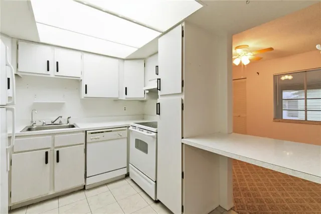a kitchen with cabinets stainless steel appliances and a sink