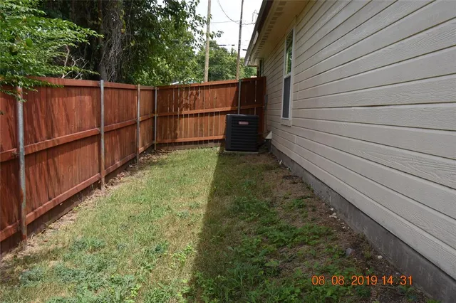 a view of a backyard with wooden fence