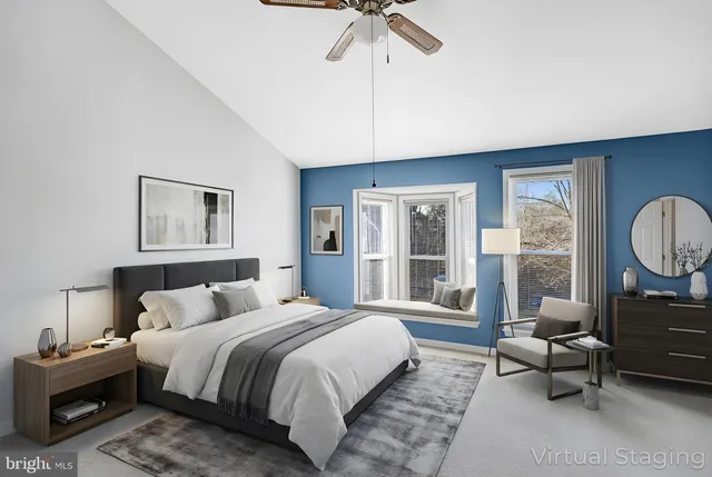 a spacious bedroom with a bed a couch and large window