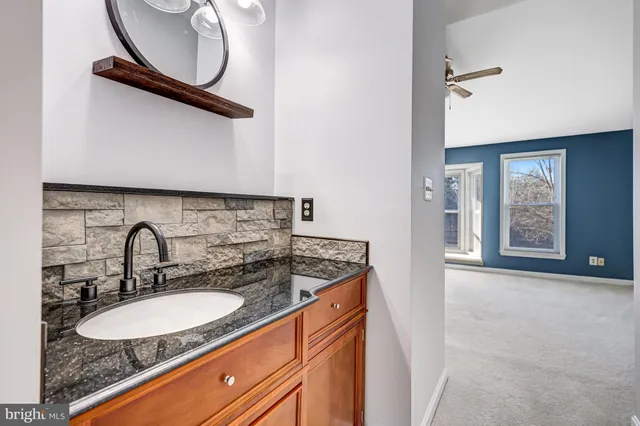 a bathroom with a granite countertop sink and a mirror