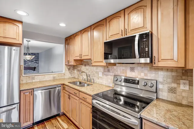a kitchen with stainless steel appliances a stove sink microwave and cabinets