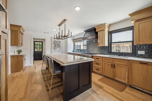a kitchen with stainless steel appliances granite countertop a sink stove and refrigerator