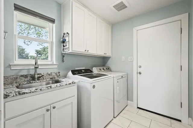 a kitchen with granite countertop white cabinets and stainless steel appliances