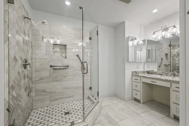 a bathroom with a granite countertop double vanity sink shower and a mirror