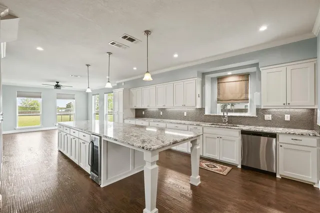 a large kitchen with kitchen island granite countertop lots of counter space and a sink