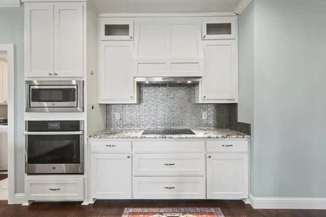 a open kitchen with granite countertop white cabinets and white appliances