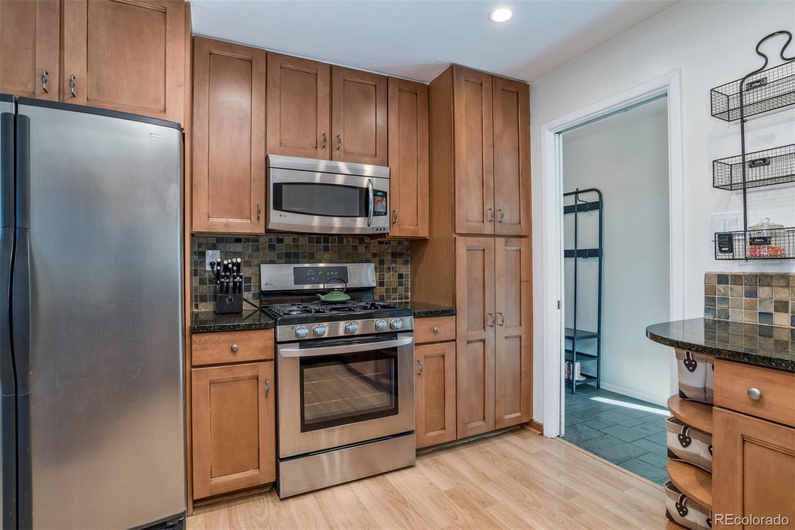 3435 Ward Road Wheat Ridge, CO 80033 - Photo 11 of 32 a kitchen with stainless steel appliances granite countertop a refrigerator stove and sink