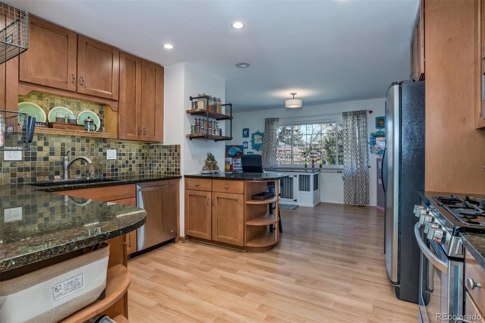 3435 Ward Road Wheat Ridge, CO 80033 - Photo 12 of 32 a kitchen with stainless steel appliances granite countertop a stove a sink and a refrigerator