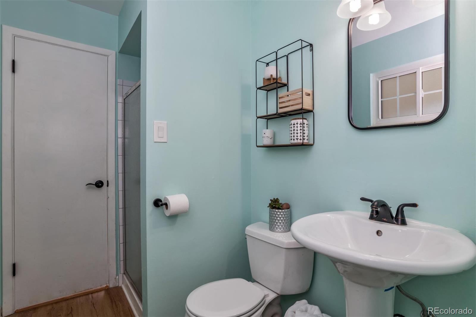 3435 Ward Road Wheat Ridge, CO 80033 - Photo 17 of 32 a bathroom with a toilet sink and mirror