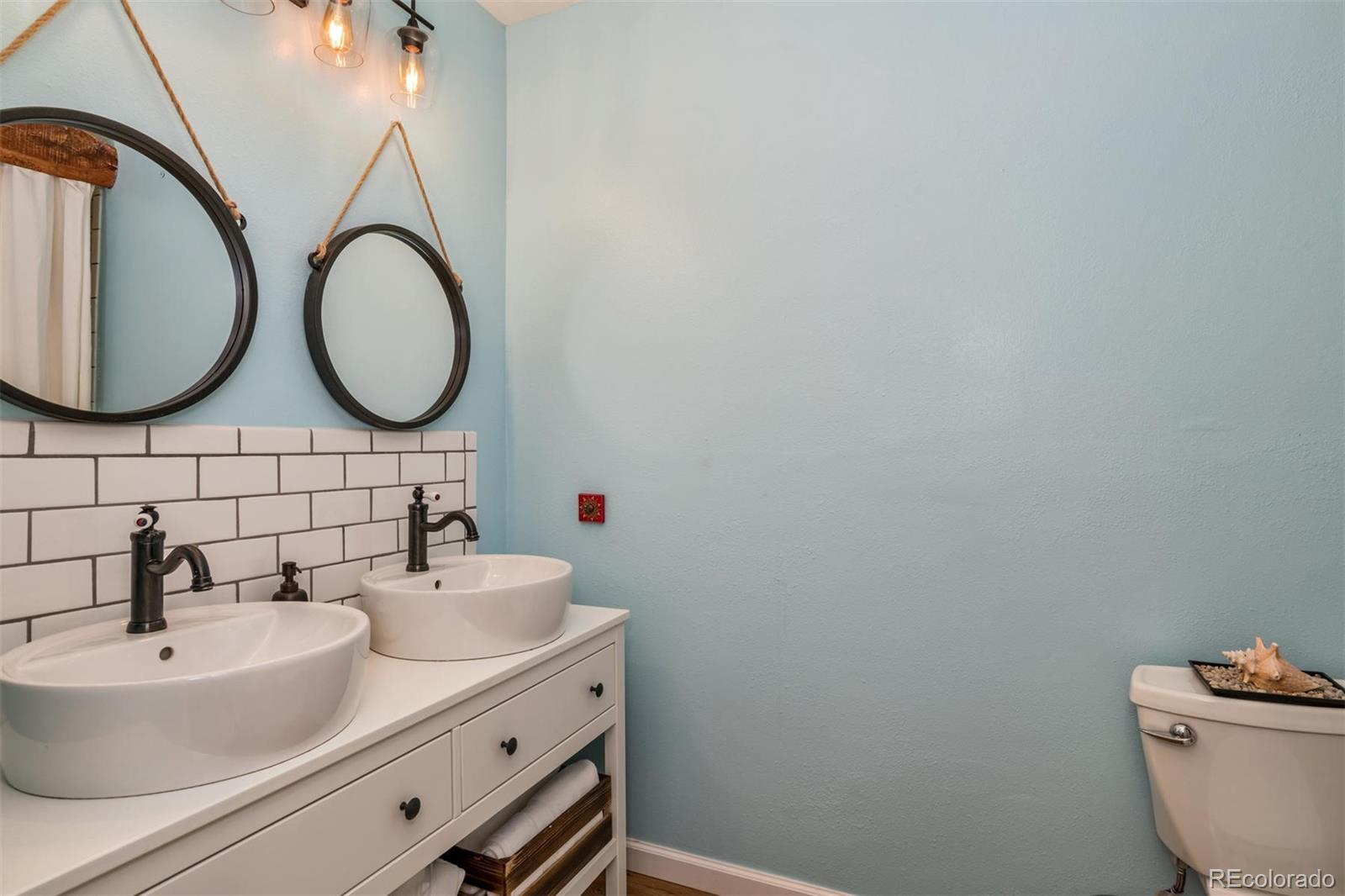 3435 Ward Road Wheat Ridge, CO 80033 - Photo 22 of 32 a bathroom with a sink and a mirror
