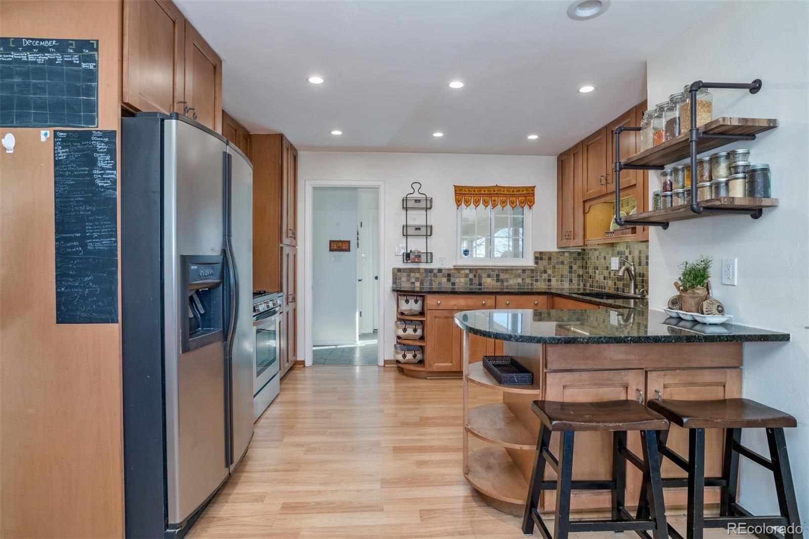 3435 Ward Road Wheat Ridge, CO 80033 - Photo 8 of 32 a kitchen with stainless steel appliances granite countertop a refrigerator and a stove top oven