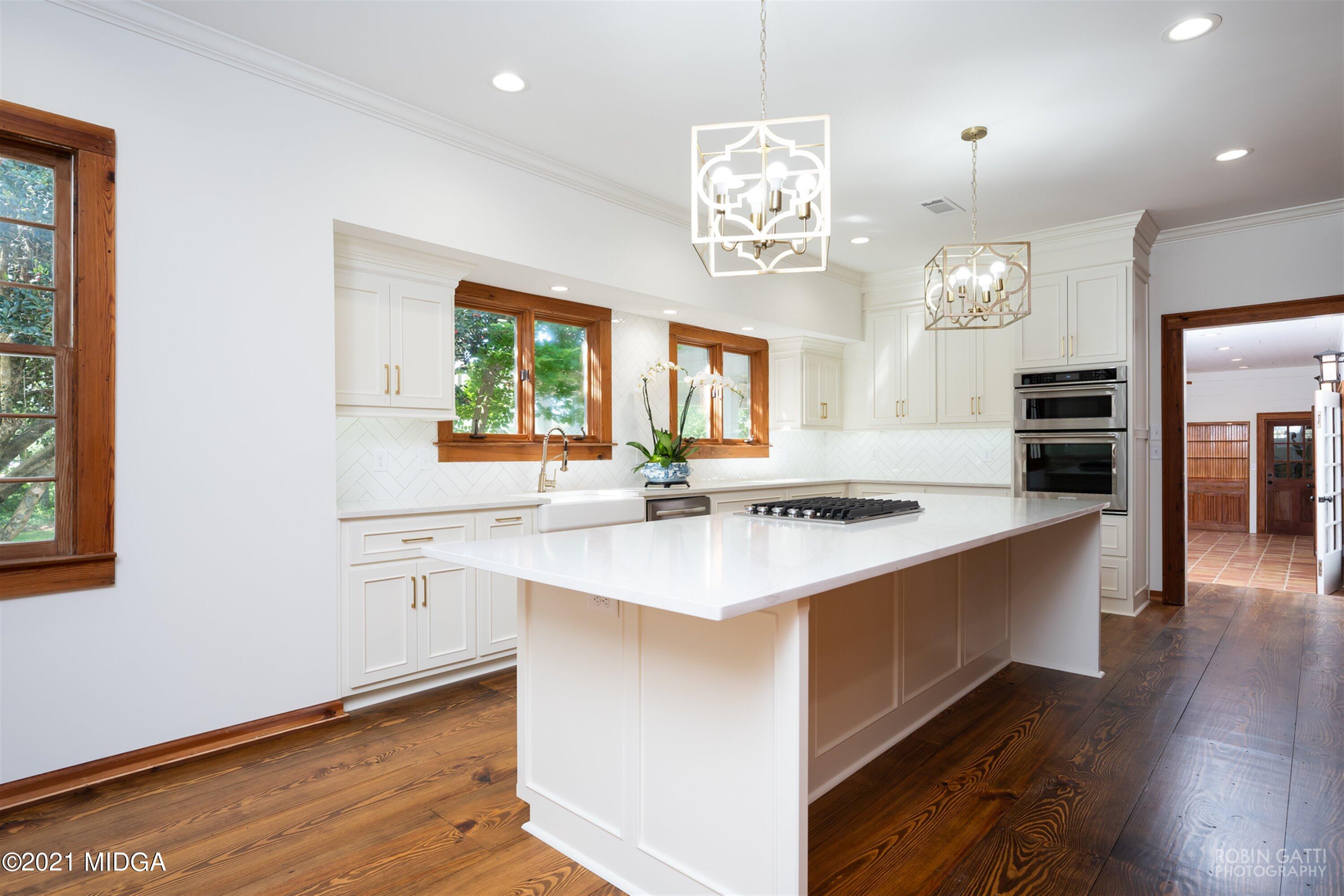 2569 Maynards Mill Road Forsyth, GA 31029 - Photo 29 of 67 a large kitchen with stainless steel appliances a large counter top a stove and a chandelier