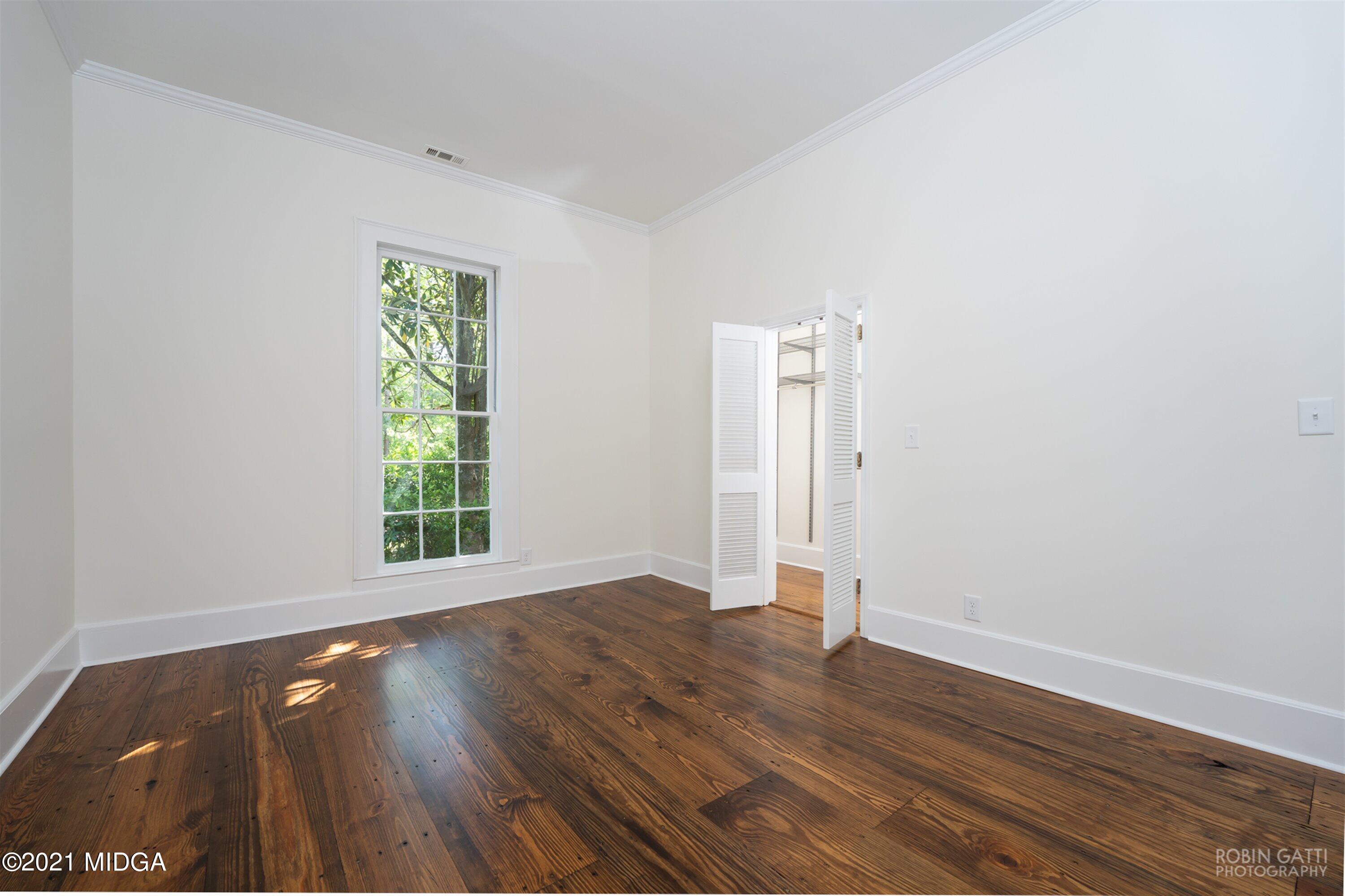 2569 Maynards Mill Road Forsyth, GA 31029 - Photo 39 of 67 an empty room with wooden floor and windows