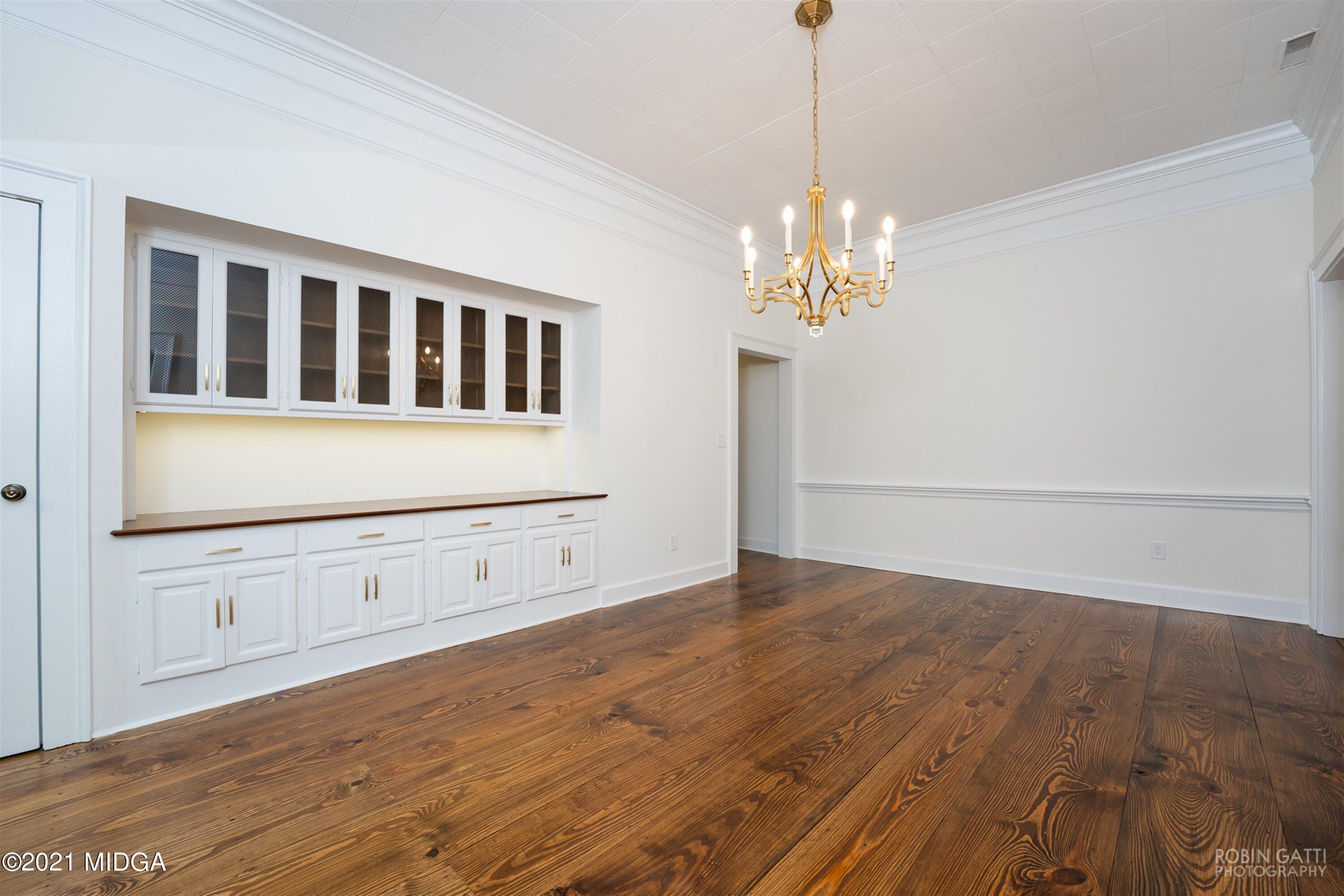 2569 Maynards Mill Road Forsyth, GA 31029 - Photo 41 of 67 a view of an empty room with chandelier and wooden floor