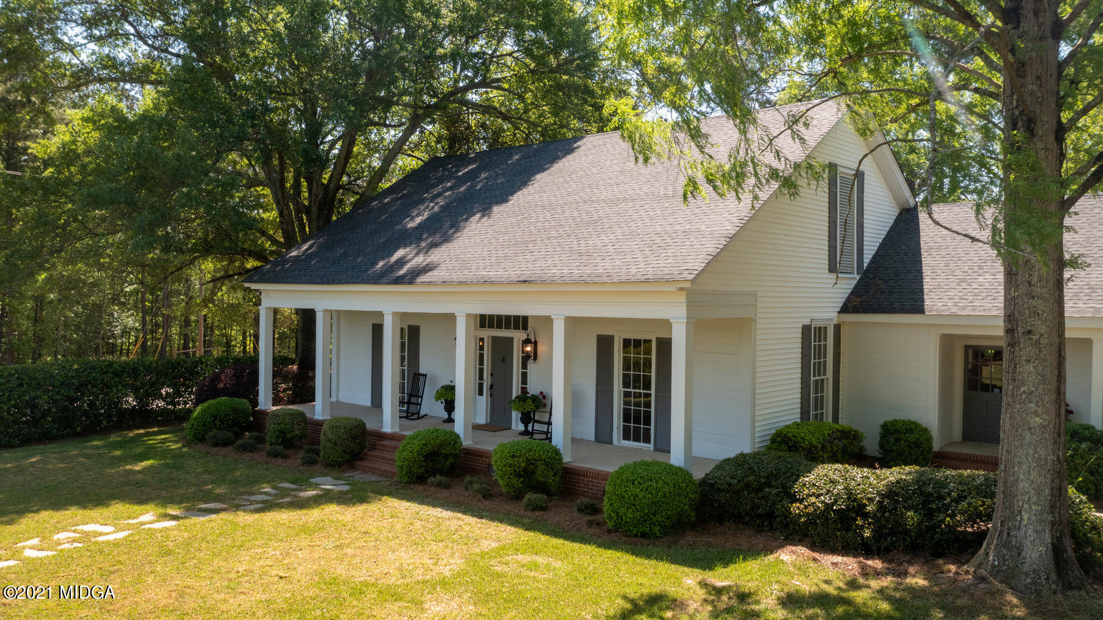 2569 Maynards Mill Road Forsyth, GA 31029 - Photo 62 of 67 a view of a white house with a yard plants and large tree