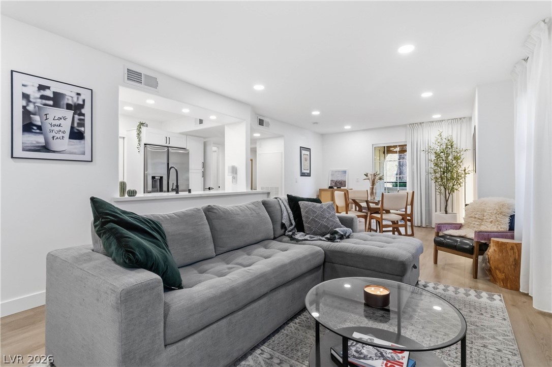 7950 West Flamingo Road, Unit 1180 Las Vegas, NV 89147 - Photo 6 of 26 An open concept living area features recessed lighting and durable hardwood flooring.