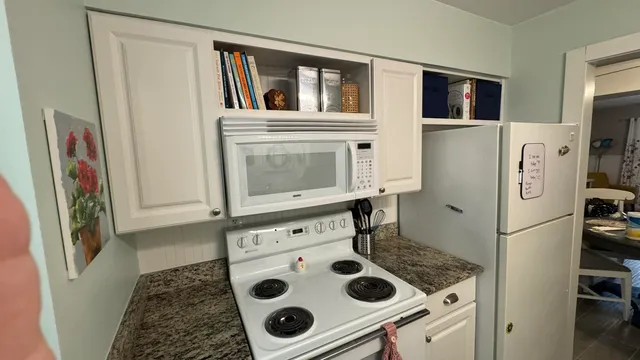 a view of kitchen island with furniture and refrigerator