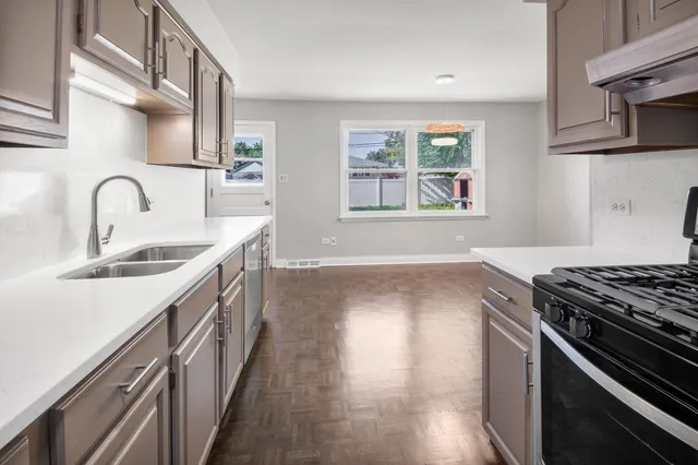 a kitchen with granite countertop a sink stove and cabinets