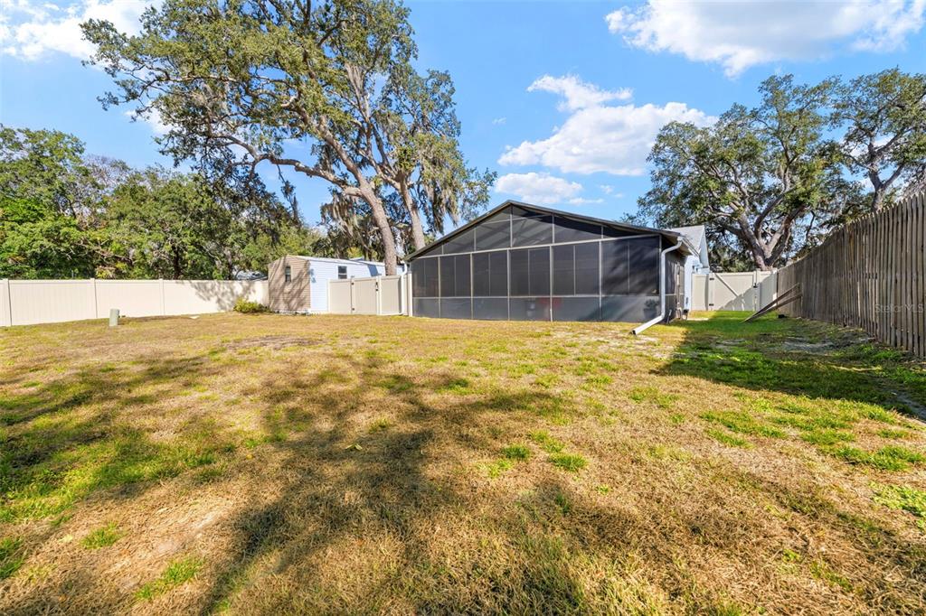 2399 Gallagher Avenue Spring Hill, FL 34606 - Photo 15 of 56 a white house that has a big yard with large trees