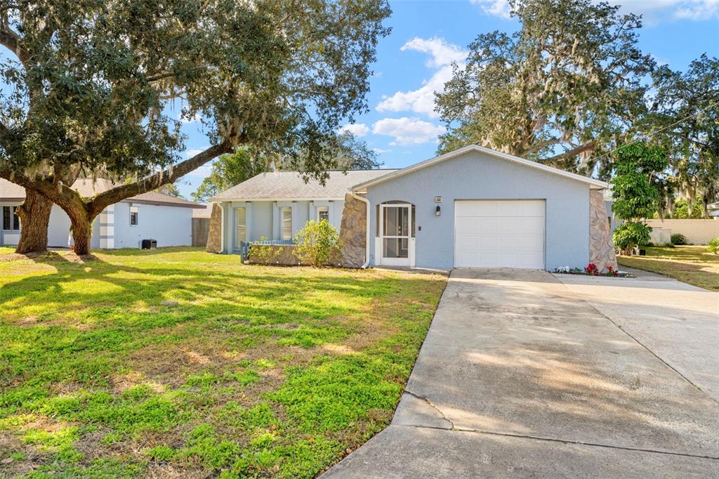 2399 Gallagher Avenue Spring Hill, FL 34606 - Photo 21 of 56 a front view of a house with a garden